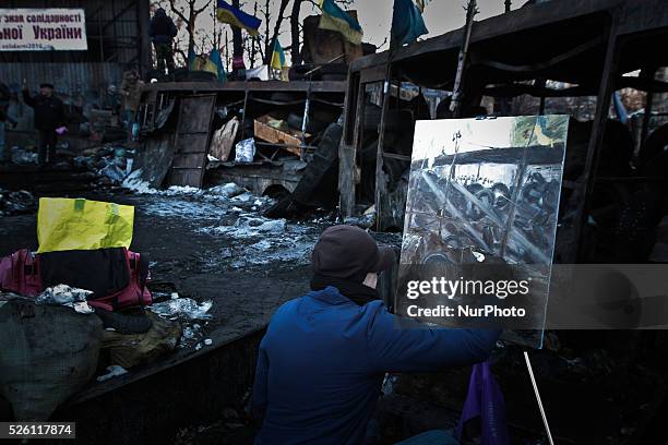 Man painting the oil on canvas picture of barricade line on Hrushevskoho street in Kiev