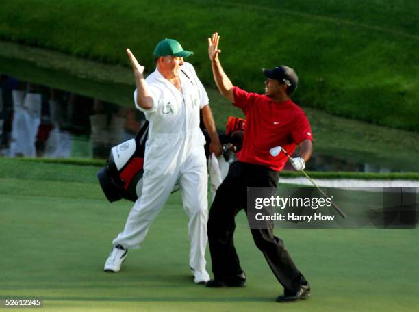 Tiger Woods and his caddie, Steve Williams, celebrate after Woods chipped in for birdie on the 16th hole during the final round of The Masters at the...