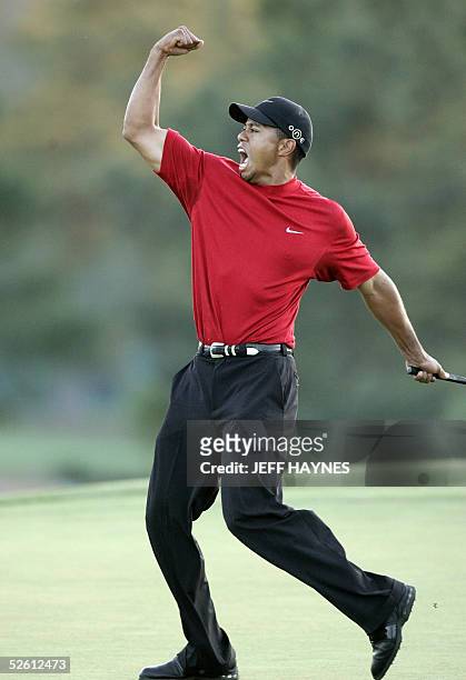 Golfer Tiger Woods celebrates after making the winning putt 10 April 2005 during the final round of the 2005 Masters Golf Tournament at the Augusta...