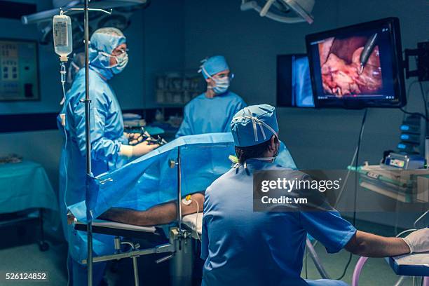 operating team doing laparoscopic surgery - laparoscopic surgery stock pictures, royalty-free photos & images
