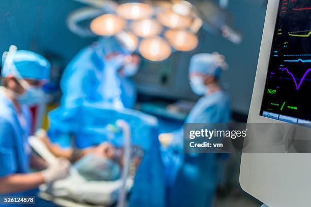 operating team conductiong a surgery - surgical equipment stock pictures, royalty-free photos & images