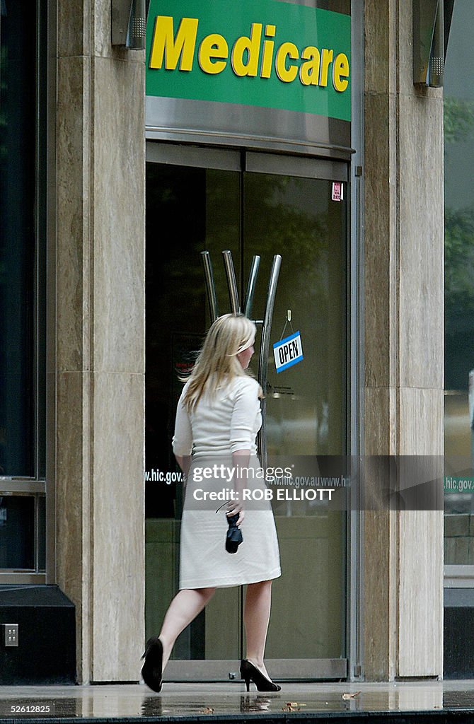 A woman walks past a Medicare (national