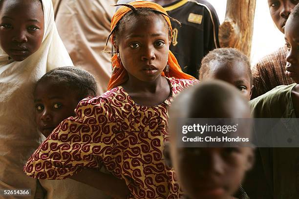 Nigieran children wait while polio is being administered April 11, 2005 on the outskirts of remote Sabongariu, Nigeria. Polio, a disease that health...