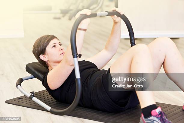 she is performing some abdominal exercises - adipositas stock pictures, royalty-free photos & images