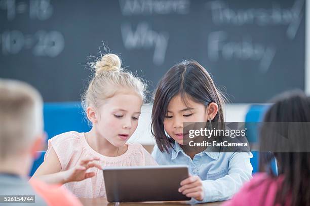 kleines mädchen mit einem digitaltablett - elementary school building stock-fotos und bilder