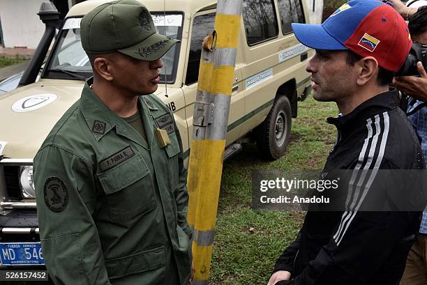Governor of Miranda state Henrique Capriles talks with a military officer asking permision to visit jailed opposition Leader Leopoldo Lopez on his...