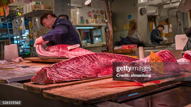 man slicing tuna in tsukiji fish market. - tonno-dalla-pinna-blù foto e immagini stock