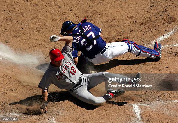 Steve Finley of the Los Angeles Angels of Anaheim slides safely past Rod Barajas of the Texas Rangers April 11, 2005 at Ameriquest Field in Arlington...