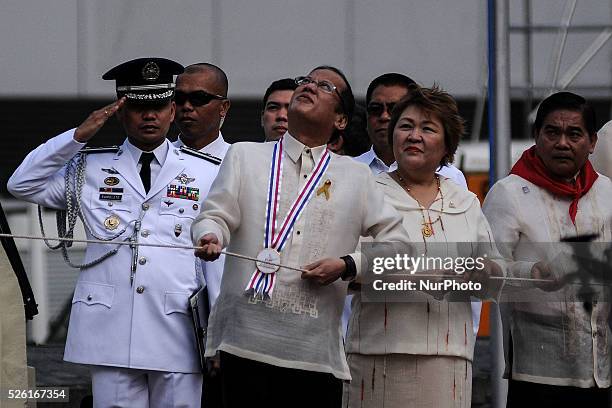 Philippine President Benigno Aquino III pulls the rope during a flag raising ceremony at the Bonifacio Monument Circle in Caloocan city, Metro...