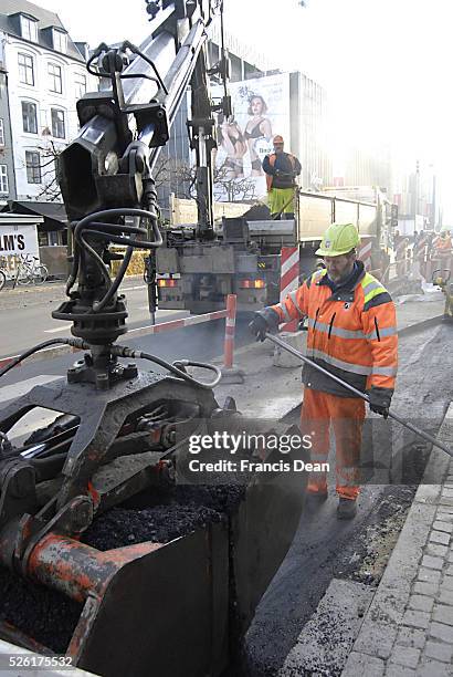 Copenhagen / Denmark. Asfalt woker meding road 24 Nov. 2012