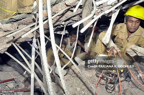 Bangladeshi rescue workers look for survivors through the debris of a collapsed factory in Palash Bari, some 30 kilometres northwest of Dhaka, 12...