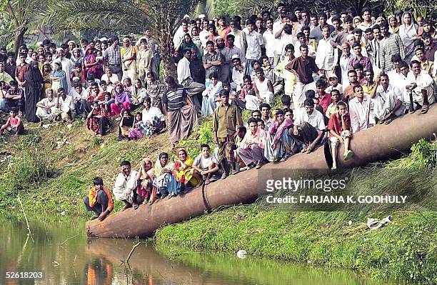 Villagers and relatives await for news of entrapped bangladeshi factory workers near the site of a factory collapsed in Palash Bari, some 30...