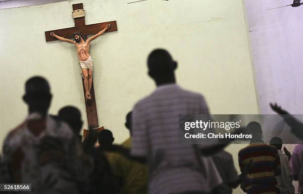 Nigerian Catholic worshippers stand and pray during morning mass April 12, 2005 in Kano, Nigeria. Kano is part of Nigeria's primarily Muslim north,...