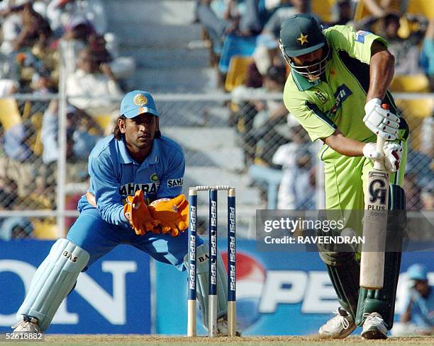 Pakistani cricket captain Inzamam-ul-Haq is watched by Indian wicketkeeper Mahender Dhoni as he plays a shot during the one day international match...