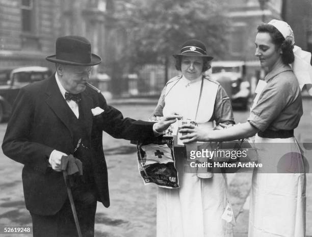 British Prime Minister Winston Churchill buys a flag on Red Cross Flag day, 5th June 1941.