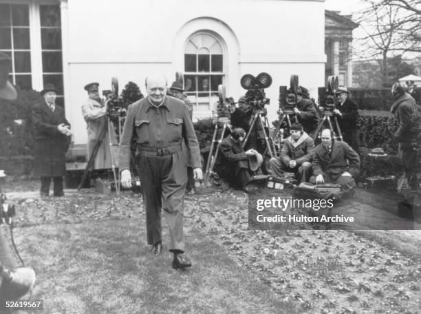 British Prime Minister Winston Churchill poses for the cameras in the grounds of the White House, wearing his 'siren suit', a one-piece garment which...