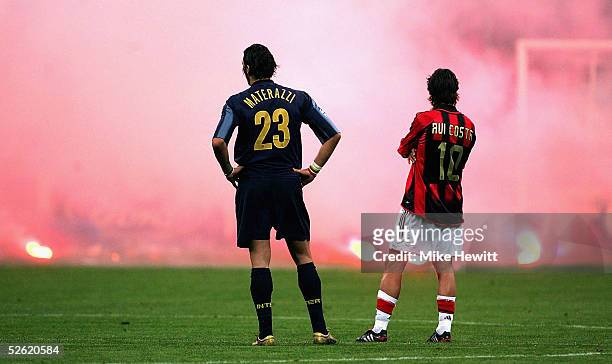 Marco Materazzi of Inter Milan and Rui Costa of AC Milan look on as Inter fans shower the pitch with flares during the UEFA Champions League...