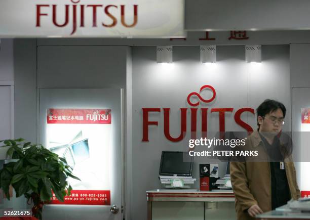 Chinese customer looks at Japanese Fujitsu computers in a store in Beijing 13 April 2005. Senior officials from Japan, China and South Korea are in...