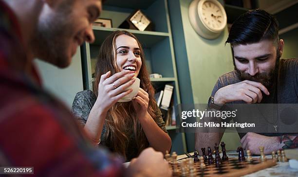 friends playing chess in urban cafe - game night leisure activity stock pictures, royalty-free photos & images