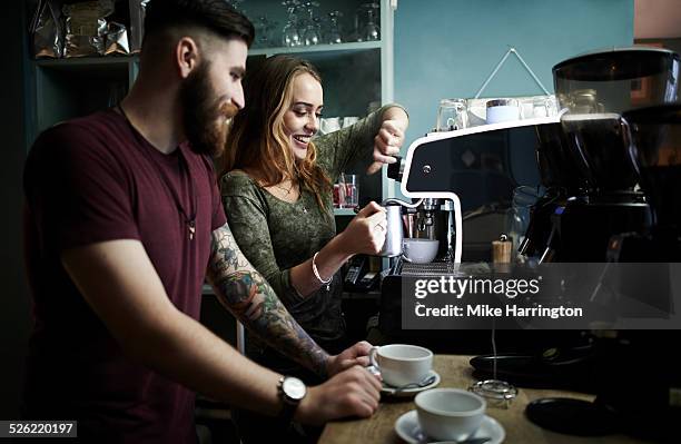 young baristas preparing drinks in cafe - bar man t shirt stock-fotos und bilder