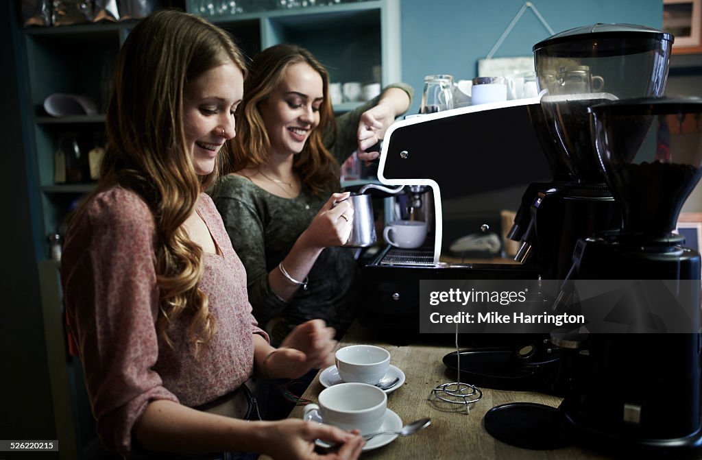 Two young baristas working in cafe