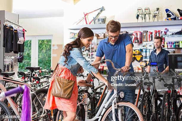 young woman watching bicycle in sport store - bicycle shop 個照片及圖片檔