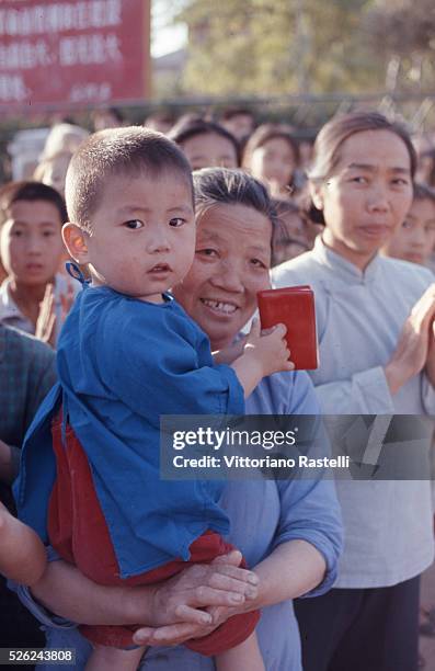 Beijing, China - A mother holds in her arms her child attending a nursery school and he holds Mao Zedong,s Red Book in Beijing, May 21 1971