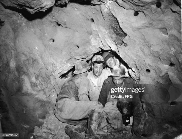 Andy Amisano and George Lamb , two tunnel diggers , are among the first to cross the breakthrough between two sections of tunnel dug from opposite...