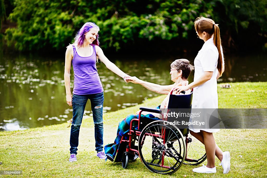 Happy family! Teenage non-conformist holds hands with grandmother; nurse watching