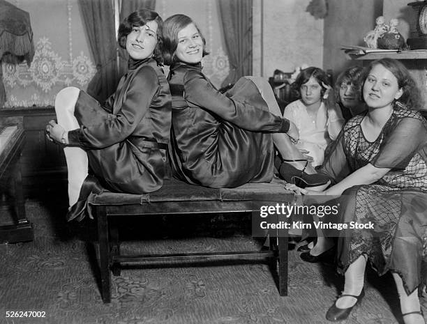 Happy young women pose in living room.