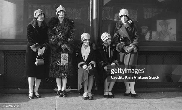 Five flappers wait on a sidewalk, ca. 1926