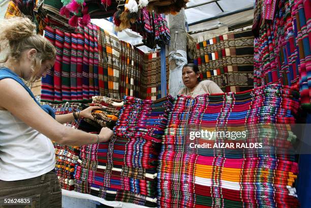 Woman looks at "aguayos", Bolivian typical fabric, in a stall in La Paz, 11 March 2005. With a population of 8.724.156 inhabitants according to the...