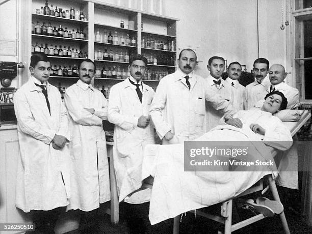 Male doctors surround a female patient in Germany, ca. 1920