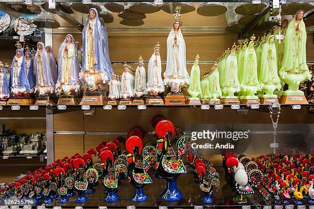Portugal, Lisbon : Small statues of Fatima Virgen displayed in a souvenir shop. They are proof of the religion weight in the country, and are placed...