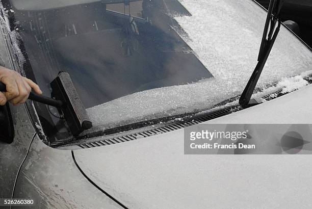 Man scrubbing frozen ice from his car window today on cold winter day 26 January 2012