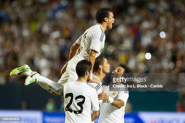 Real Madrid player Cristiano Ronaldo gets help celebrating his goal from teammates Pepe , Marcelo , and Isco during the Championship match between...
