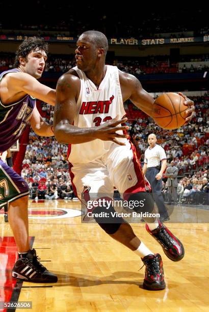 Shaquille O'Neal#34 of the Miami Heat drives around Zaza Pachulia#27 of the Milwaukee Bucks during NBA action on March 14, 2005 at American Airlines...