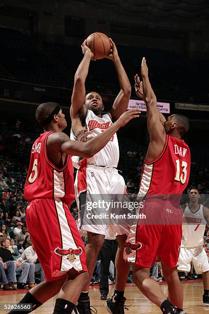 Malik Allen of the Charlotte Bobcats springs up for two between Josh Smith and Boris Diaw of the Atlanta Hawks on April 13, 2005 at the Charlotte...