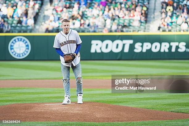 Rapper Macklemore throws the first pitch of the Seattle Mariners vs. Kansas City Royals Major League Baseball game during '"Bumbershoot Night" at...