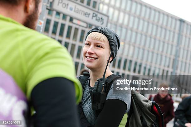 female bike messenger talking with colleague - bike messenger stock-fotos und bilder