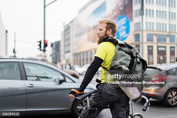 bike messenger waiting on crossroad - road intersection stock-fotos und bilder