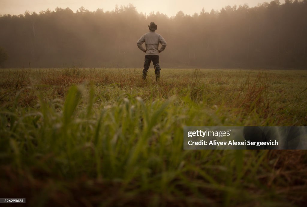 Mixed race man standing in field in rural landscape