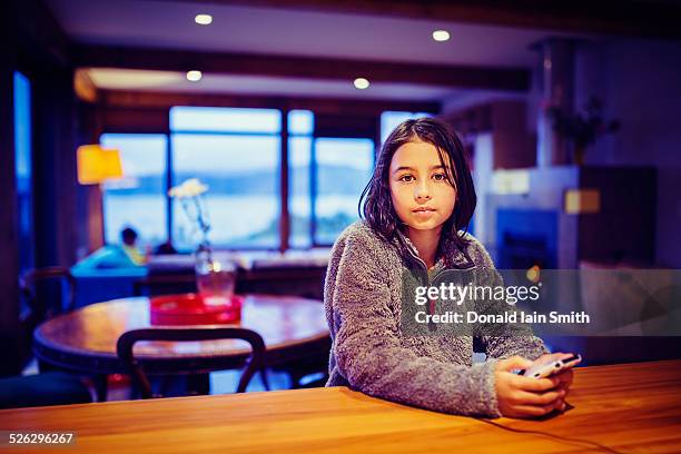 mixed race girl using cell phone at table - 11 year old indian girl stock pictures, royalty-free photos & images