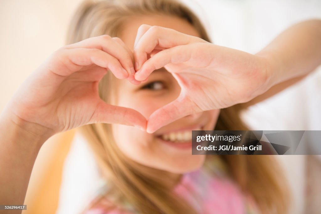 Caucasian girl making heart shape with hands