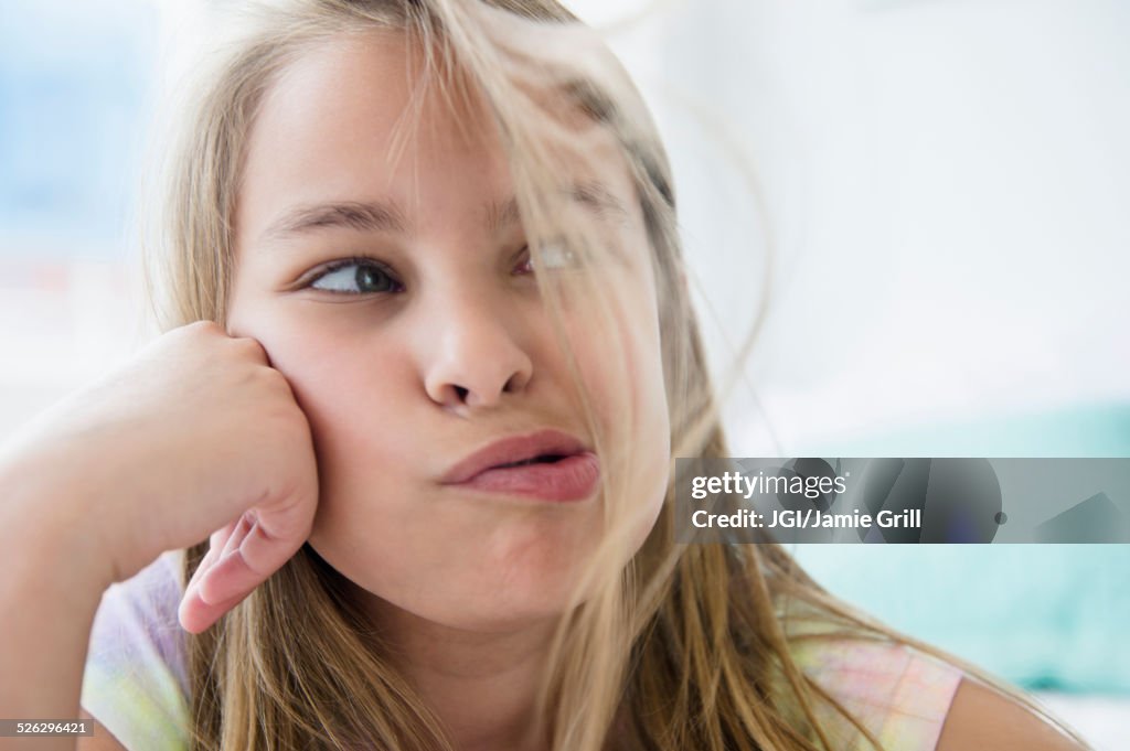 Caucasian girl blowing hair from her face