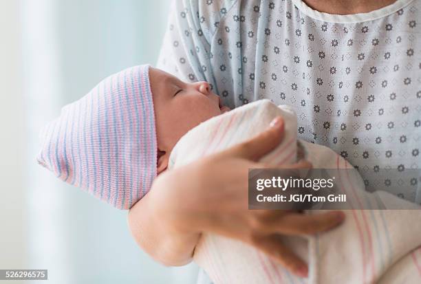 asian mother holding newborn baby in hospital - sala de maternidad fotografías e imágenes de stock