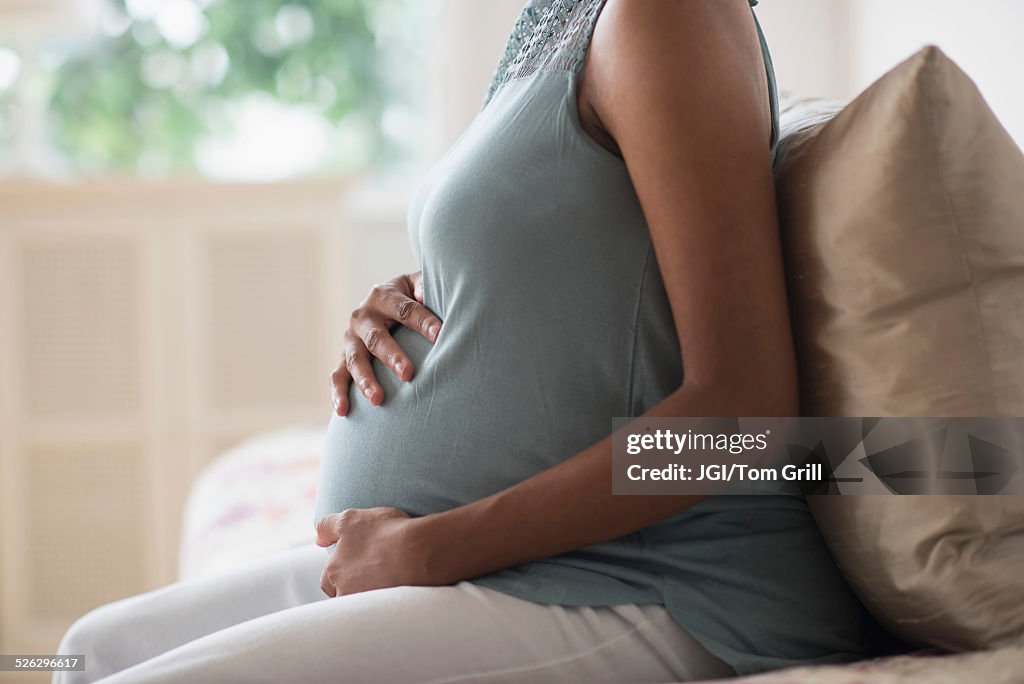 Pregnant African American mother holding her stomach