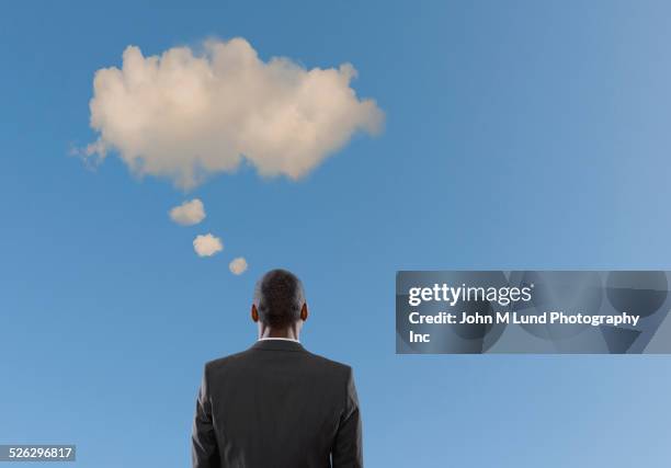 mixed race businessman standing under thought bubble cloud - thought bubble 個照片及圖片檔