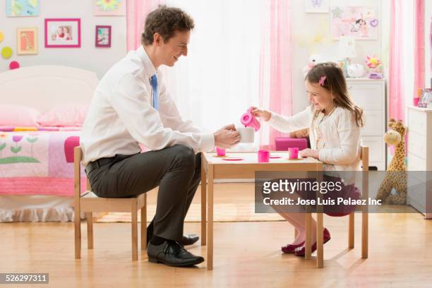 caucasian father and daughter having tea party in bedroom - tea party stock pictures, royalty-free photos & images