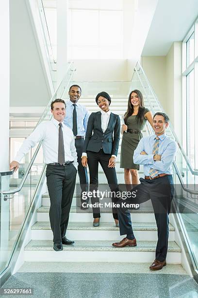 business people smiling on office staircase - five people standing stock pictures, royalty-free photos & images